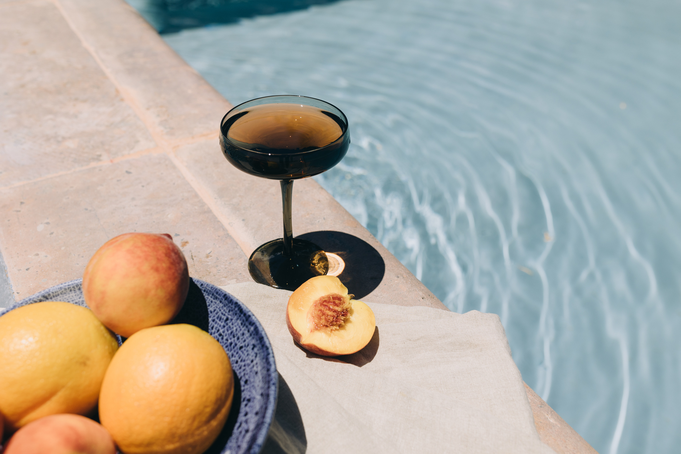 Glass of Wine and Peaches by the Swimming Pool